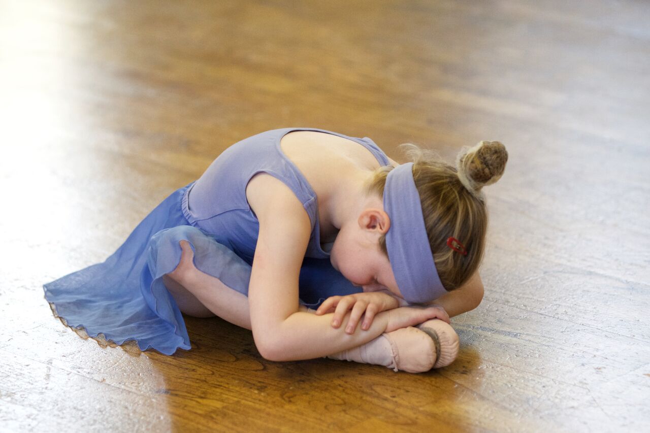 primary ballet girl bending down